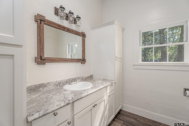 bathroom with vanity, baseboards, and wood finished floors