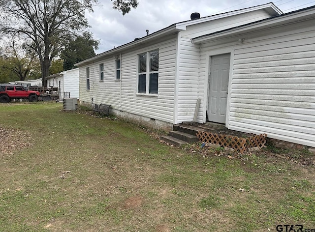 exterior space featuring central AC unit and a lawn