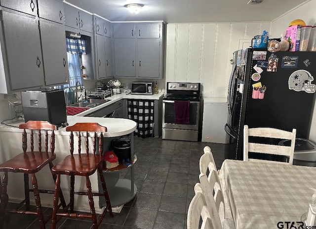 kitchen featuring gray cabinets, sink, dark tile patterned floors, and appliances with stainless steel finishes