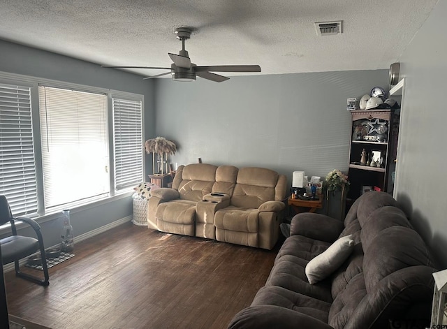 living room featuring a textured ceiling, ceiling fan, and dark wood-type flooring