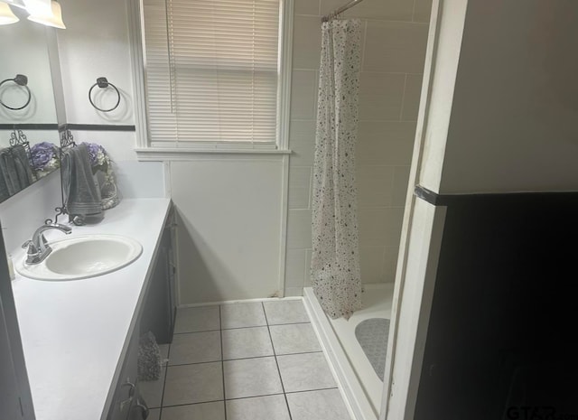 bathroom featuring tile patterned flooring, vanity, and curtained shower