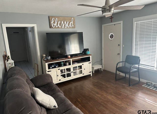 living room featuring a textured ceiling, ceiling fan, and dark hardwood / wood-style floors