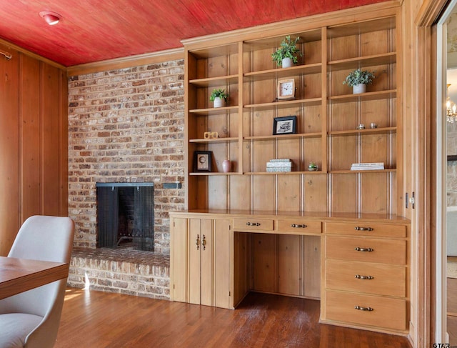 interior space featuring a brick fireplace, built in features, wood ceiling, and dark hardwood / wood-style flooring