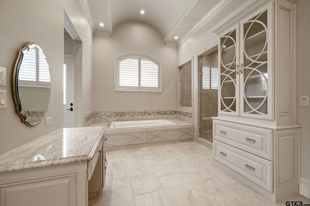 5581 Nancy Cir, Chandler, TX 75758 - full bathroom featuring vanity, a garden tub, a stall shower, marble look tile flooring, and ornamental molding