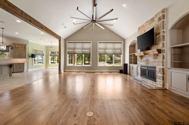 5581 Nancy Cir, Chandler, TX 75758 - unfurnished living room with a stone fireplace, light wood finished floors, built in features, baseboards, and high vaulted ceiling