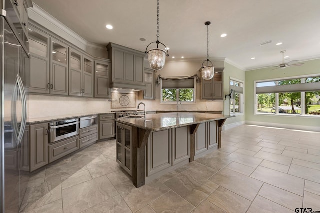 5581 Nancy Cir, Chandler, TX 75758 - kitchen with stainless steel appliances, a warming drawer, gray cabinetry, a sink, and decorative backsplash