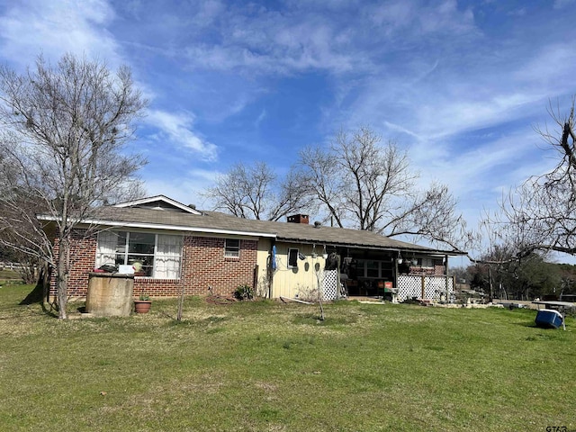 rear view of property with a yard