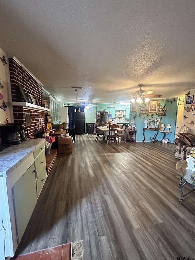 interior space with dark hardwood / wood-style flooring, ceiling fan, a textured ceiling, and a wood stove