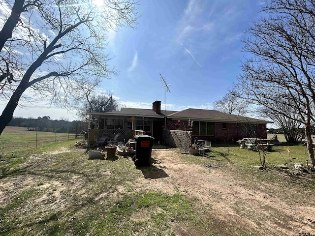 rear view of house featuring a yard