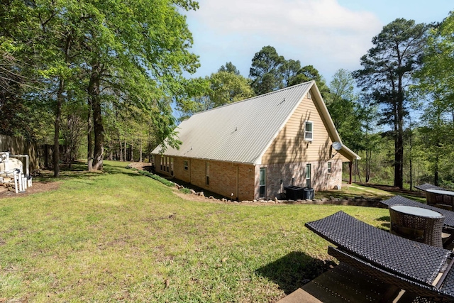 view of side of property featuring a lawn and cooling unit