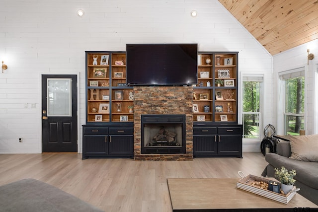 living room with light hardwood / wood-style flooring, vaulted ceiling, wooden ceiling, a fireplace, and wooden walls