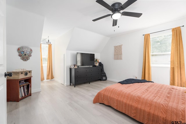 bedroom featuring ceiling fan, light hardwood / wood-style floors, and vaulted ceiling