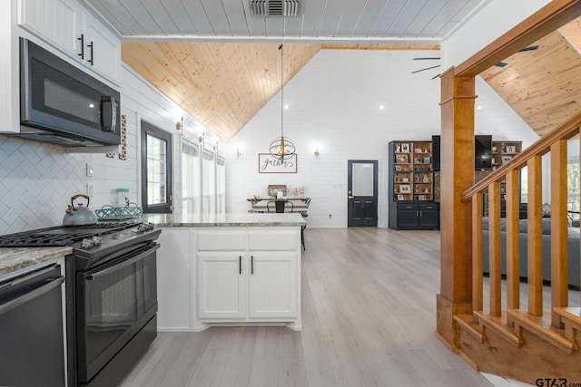 kitchen featuring light stone countertops, black gas range, stainless steel dishwasher, white cabinets, and pendant lighting