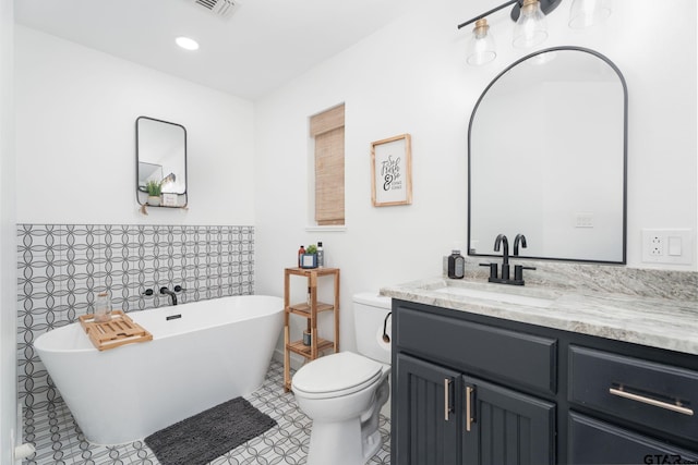 bathroom with toilet, vanity, and a washtub