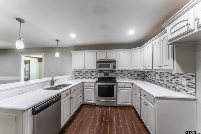 1853 Woodbridge Dr, Sulphur Springs, TX 75482 - kitchen with appliances with stainless steel finishes, a sink, decorative backsplash, a peninsula, and white cabinetry