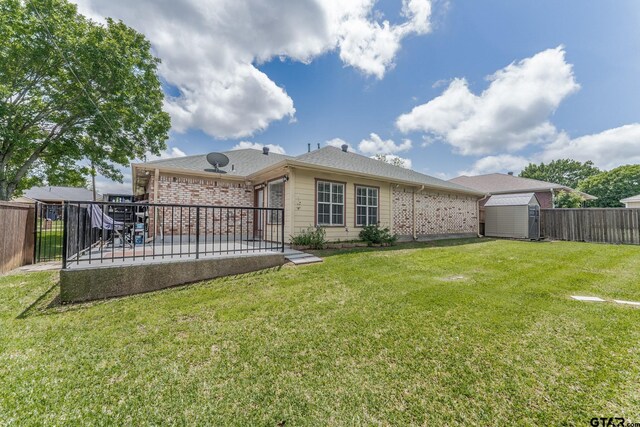 1853 Woodbridge Dr, Sulphur Springs, TX 75482 - back of property featuring a storage unit, a patio area, brick siding, and an outbuilding