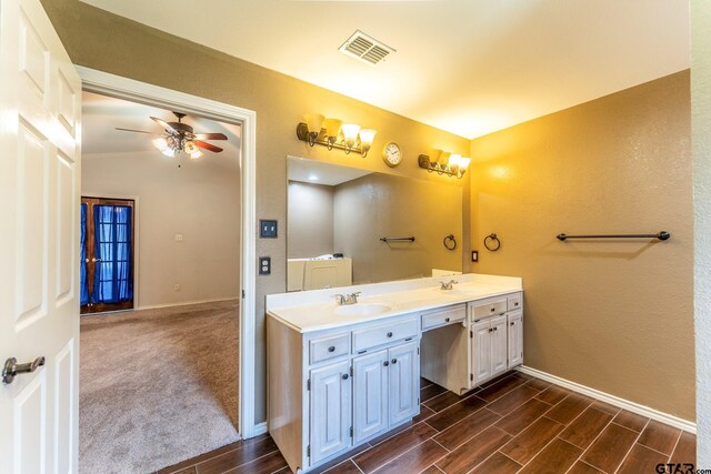 1853 Woodbridge Dr, Sulphur Springs, TX 75482 - full bath featuring baseboards, a ceiling fan, wood finished floors, and double vanity