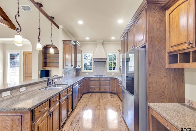 kitchen with stainless steel appliances, kitchen peninsula, decorative backsplash, pendant lighting, and premium range hood