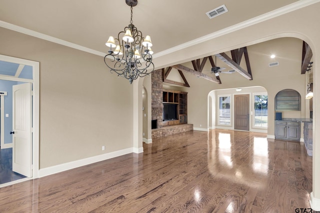 unfurnished living room with lofted ceiling with beams, hardwood / wood-style floors, ceiling fan with notable chandelier, and crown molding