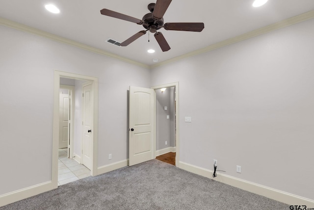 unfurnished bedroom featuring ceiling fan, light carpet, and crown molding