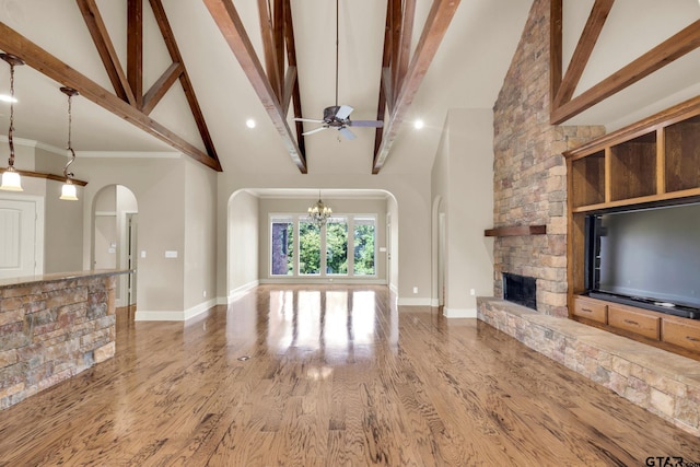 unfurnished living room with high vaulted ceiling, beamed ceiling, wood-type flooring, and a fireplace