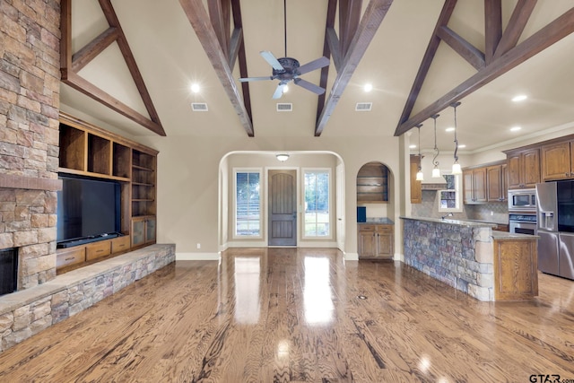 kitchen featuring stainless steel appliances, beamed ceiling, and high vaulted ceiling