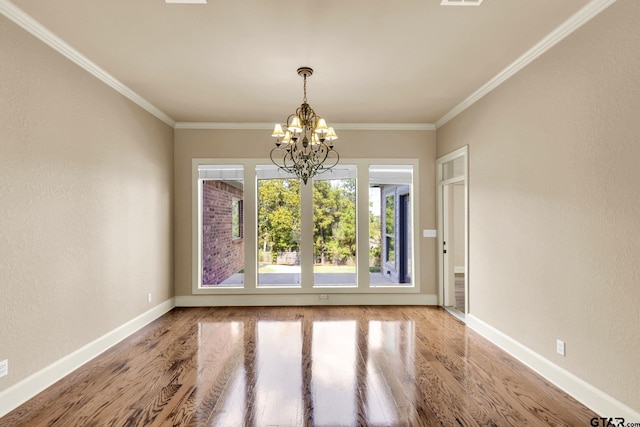 unfurnished dining area featuring hardwood / wood-style floors, an inviting chandelier, and ornamental molding