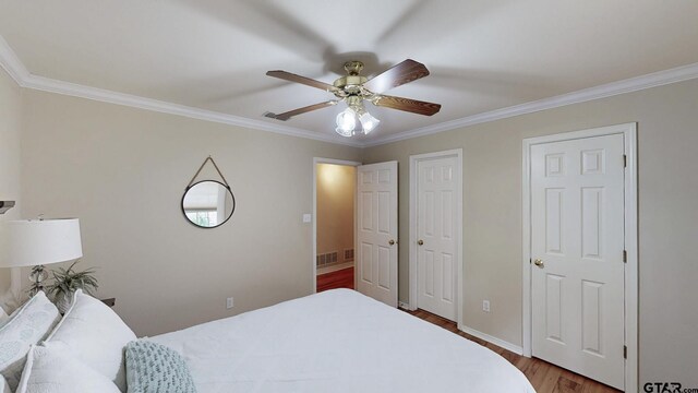 bedroom featuring baseboards, wood finished floors, and ornamental molding