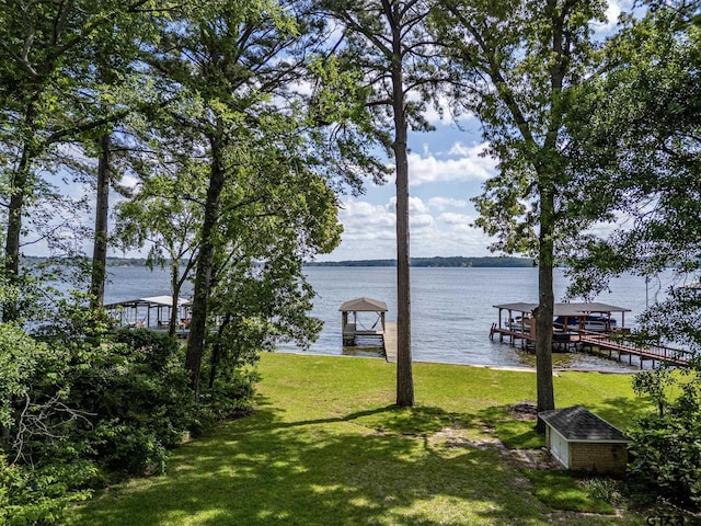 view of dock with a lawn, a water view, and boat lift