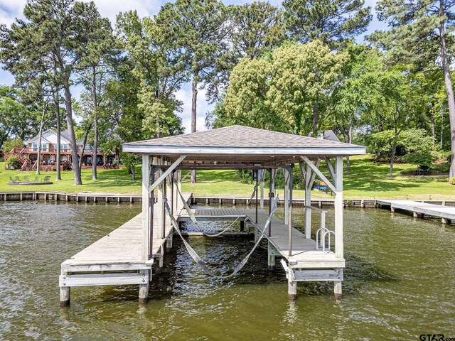 dock area featuring boat lift and a water view