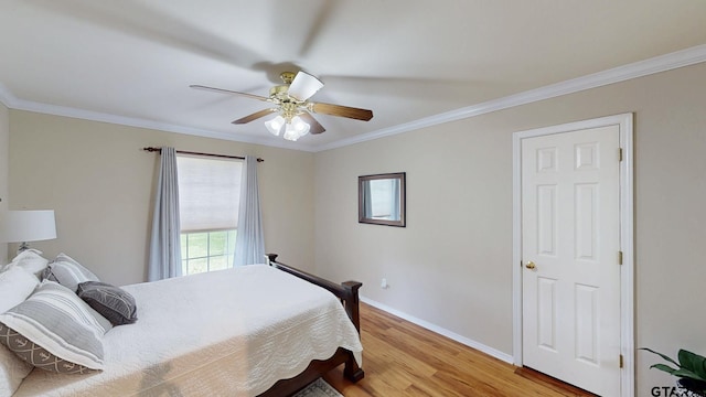 bedroom featuring light wood-type flooring, crown molding, baseboards, and a ceiling fan