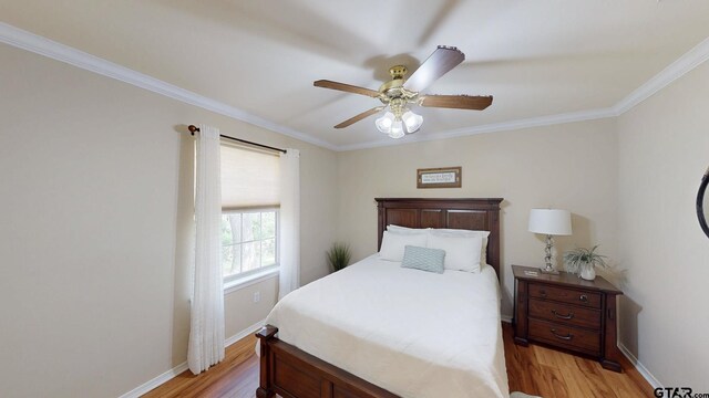 bedroom with light wood-type flooring, a ceiling fan, baseboards, and ornamental molding