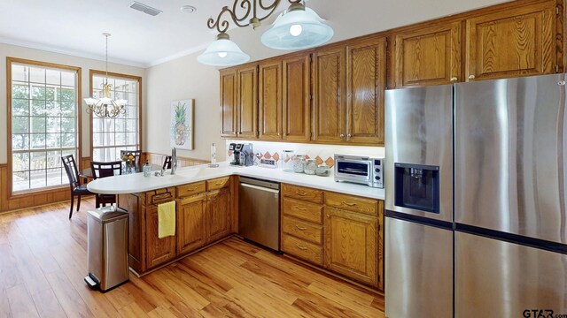 kitchen with brown cabinets, appliances with stainless steel finishes, and visible vents