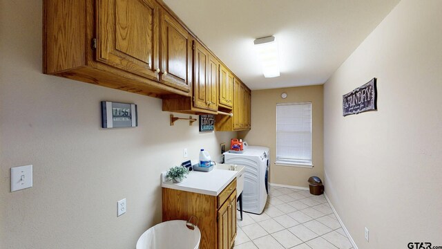 laundry area featuring light tile patterned flooring, baseboards, cabinet space, and washer and dryer