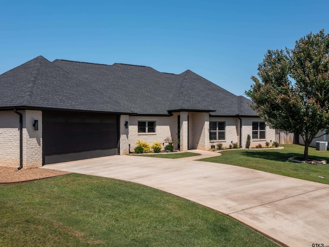 217 Providence Pl, Bullard, TX 75757 - french provincial home featuring concrete driveway, an attached garage, a shingled roof, a front yard, and brick siding