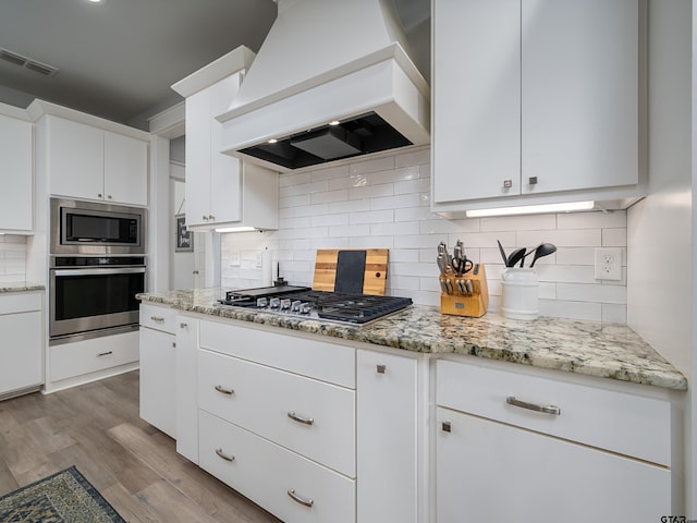 217 Providence Pl, Bullard, TX 75757 - kitchen featuring stainless steel appliances, custom range hood, wood finished floors, and white cabinetry