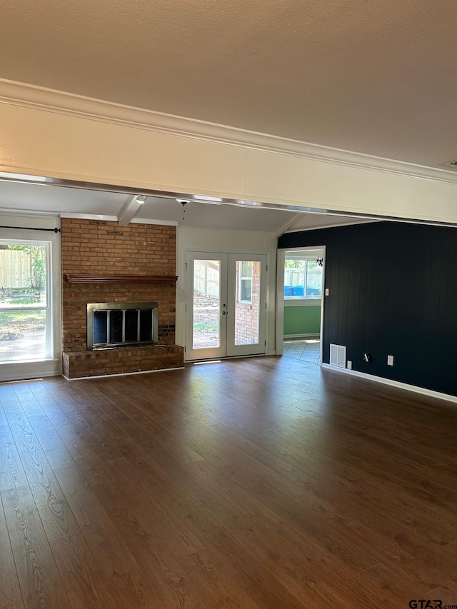 715 Belmont Dr, Athens, TX 75751 - unfurnished living room featuring dark wood-style floors, a brick fireplace, crown molding, and french doors