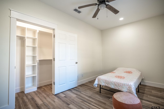 bedroom with hardwood / wood-style flooring, a spacious closet, ceiling fan, and a closet