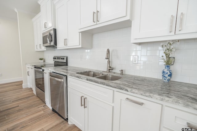 kitchen with white cabinetry, sink, backsplash, and appliances with stainless steel finishes