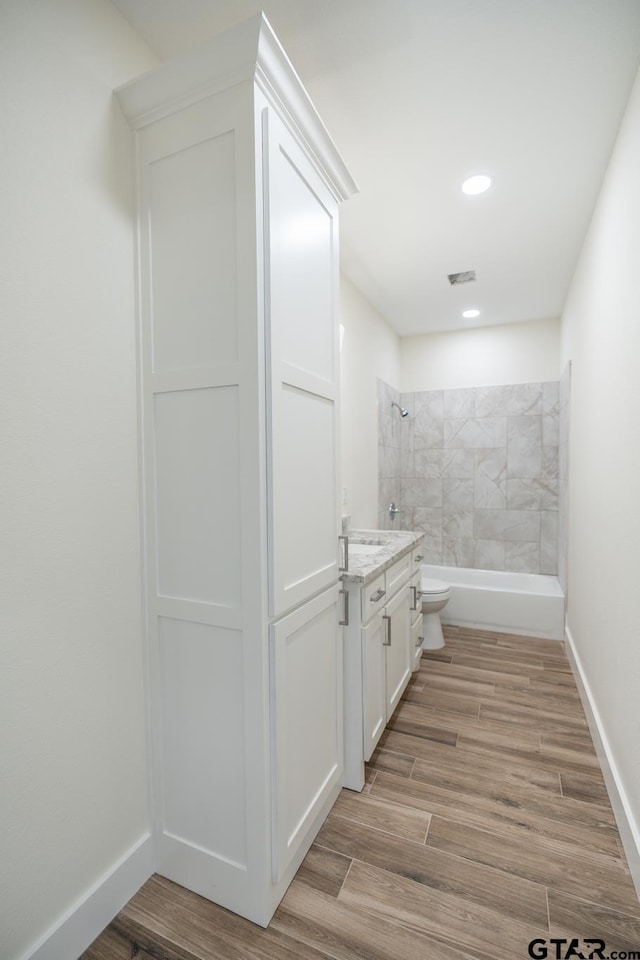 full bathroom with vanity, tiled shower / bath combo, and toilet