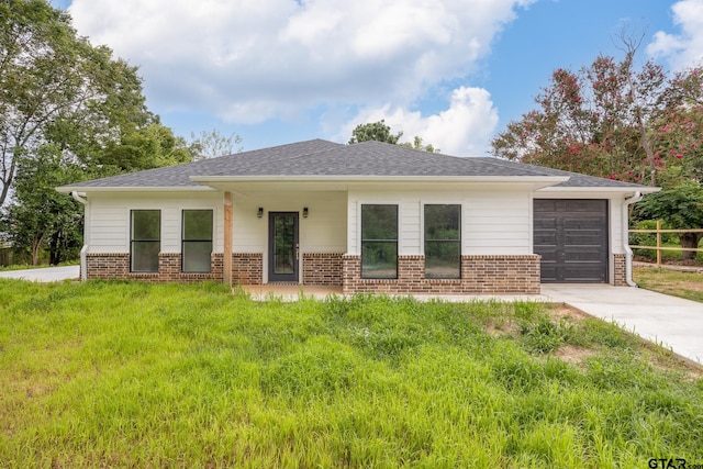 view of front of house featuring a garage and a front lawn