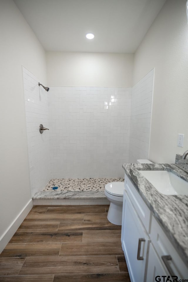 bathroom with vanity, a tile shower, and toilet