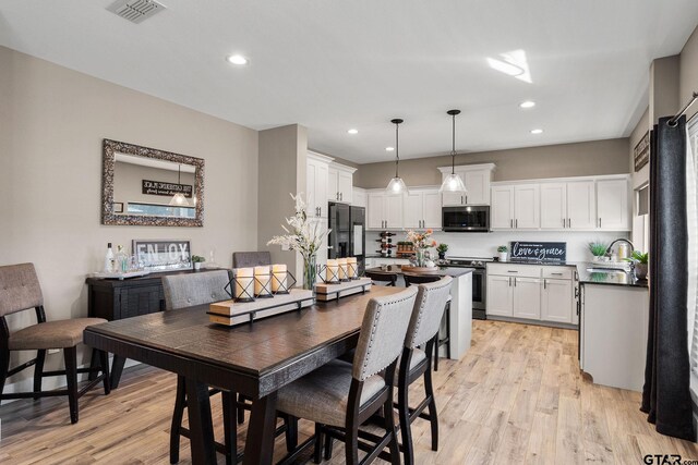 dining room with light hardwood / wood-style flooring and sink