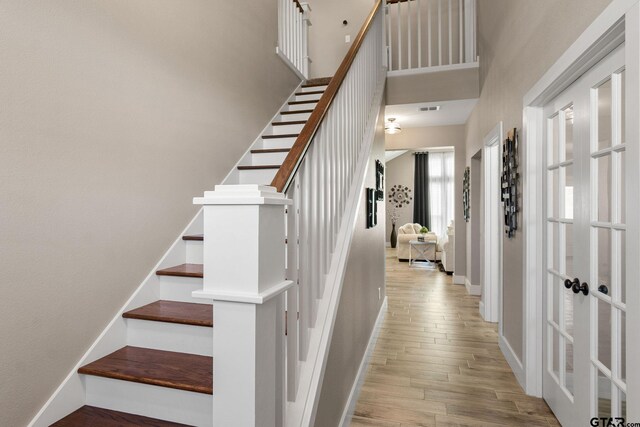 staircase with a high ceiling and hardwood / wood-style flooring