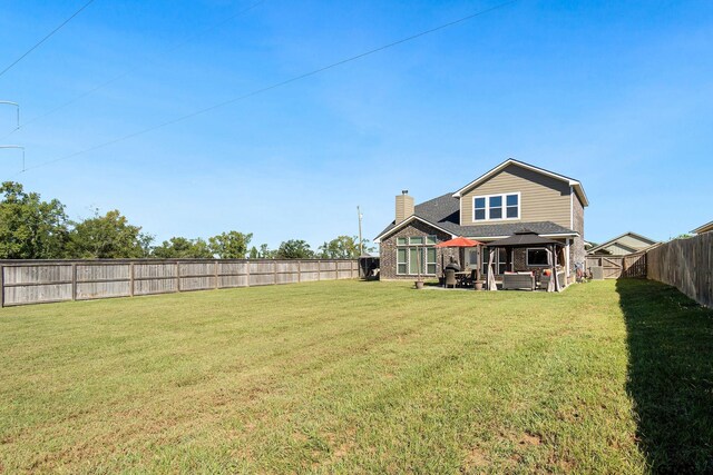 back of house with an outdoor living space, a yard, and a patio