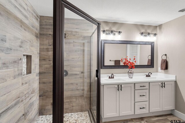 bathroom featuring hardwood / wood-style floors, vanity, and walk in shower