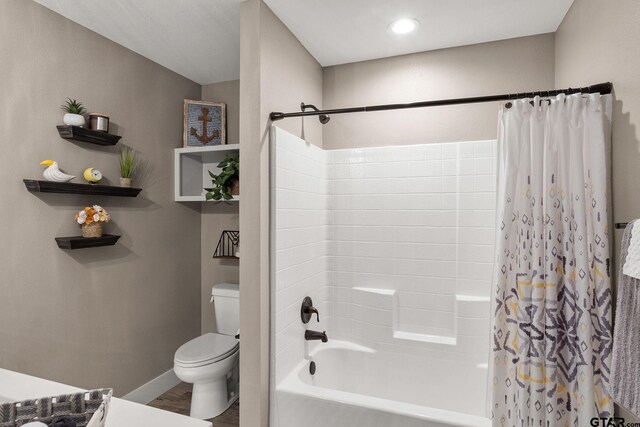 full bathroom featuring hardwood / wood-style floors, vanity, shower / tub combo, and toilet