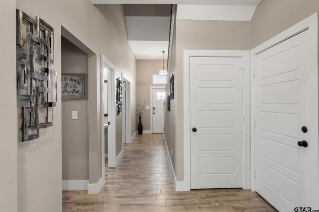 hallway with light hardwood / wood-style floors