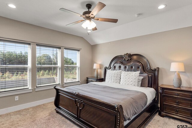 bedroom with multiple windows, light carpet, ceiling fan, and lofted ceiling