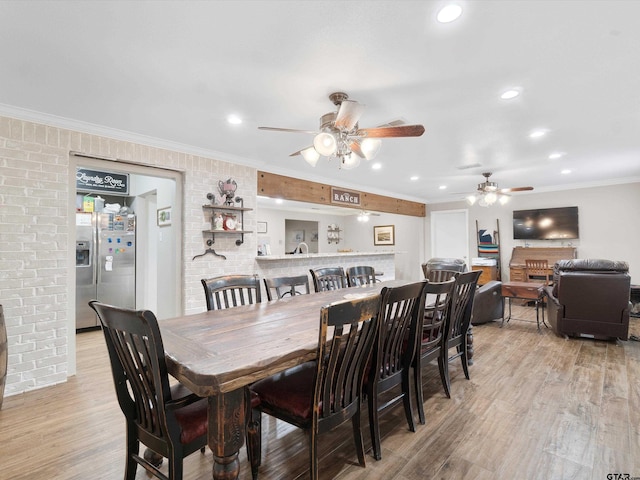 dining space featuring ceiling fan, light wood-type flooring, and crown molding